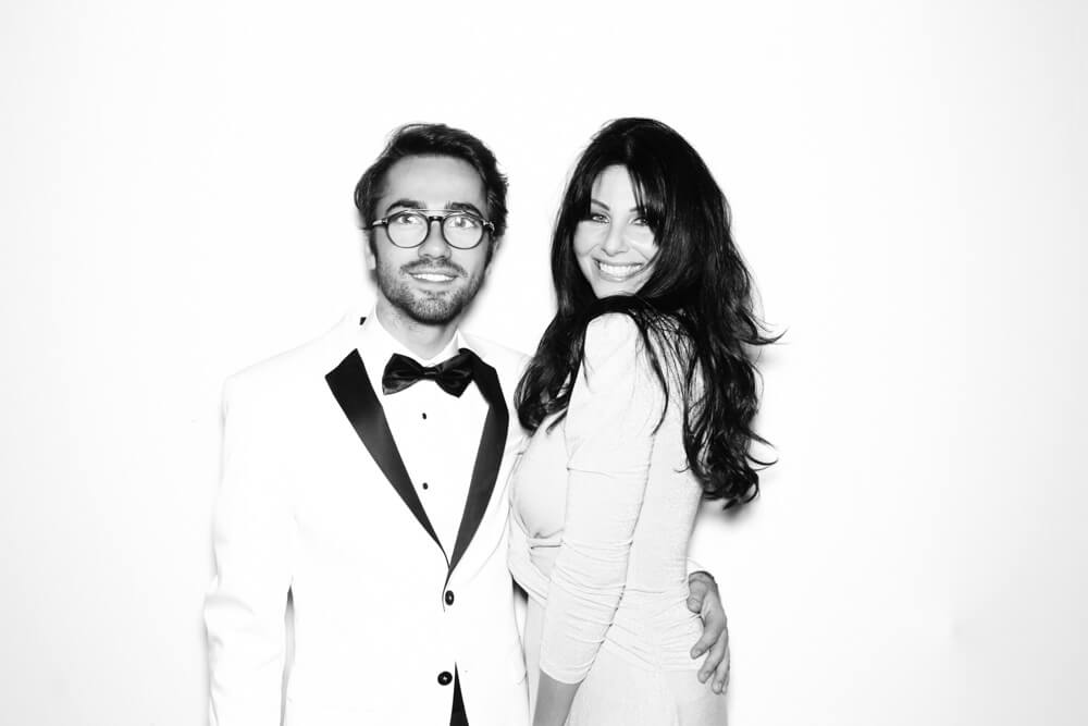 black-and-white-wedding-photo-booth-11 a man in a white tuxedo posing with a gorgeous woman