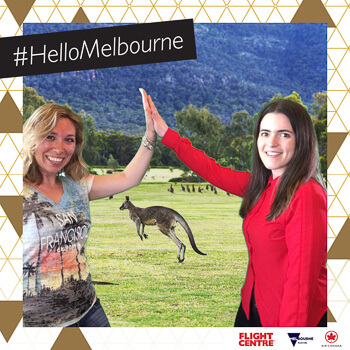 two women giving a high five near a kangaroo