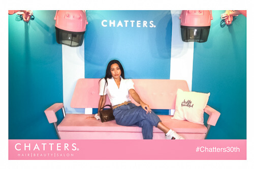 a woman posing on a pink couch in a vintage salon set