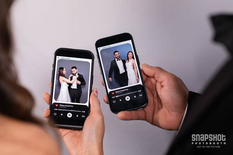 Musicgram-Photo-booth-Snapshot-1736156403 couple looking at their photo booth images on their phones