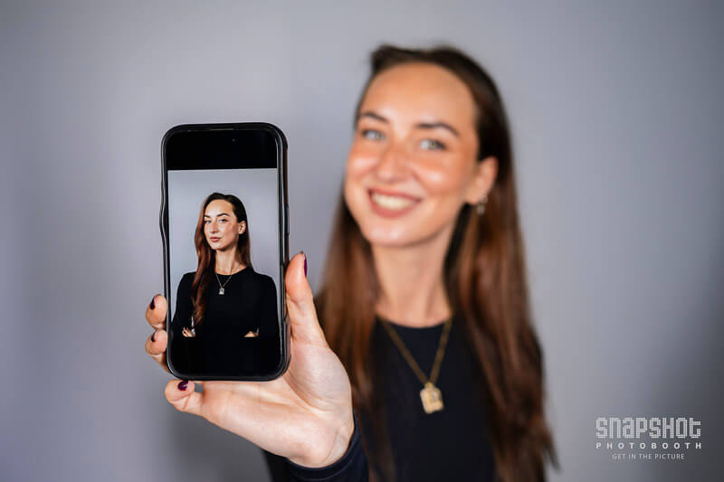 a woman showing her headshot photo on her mobile phone